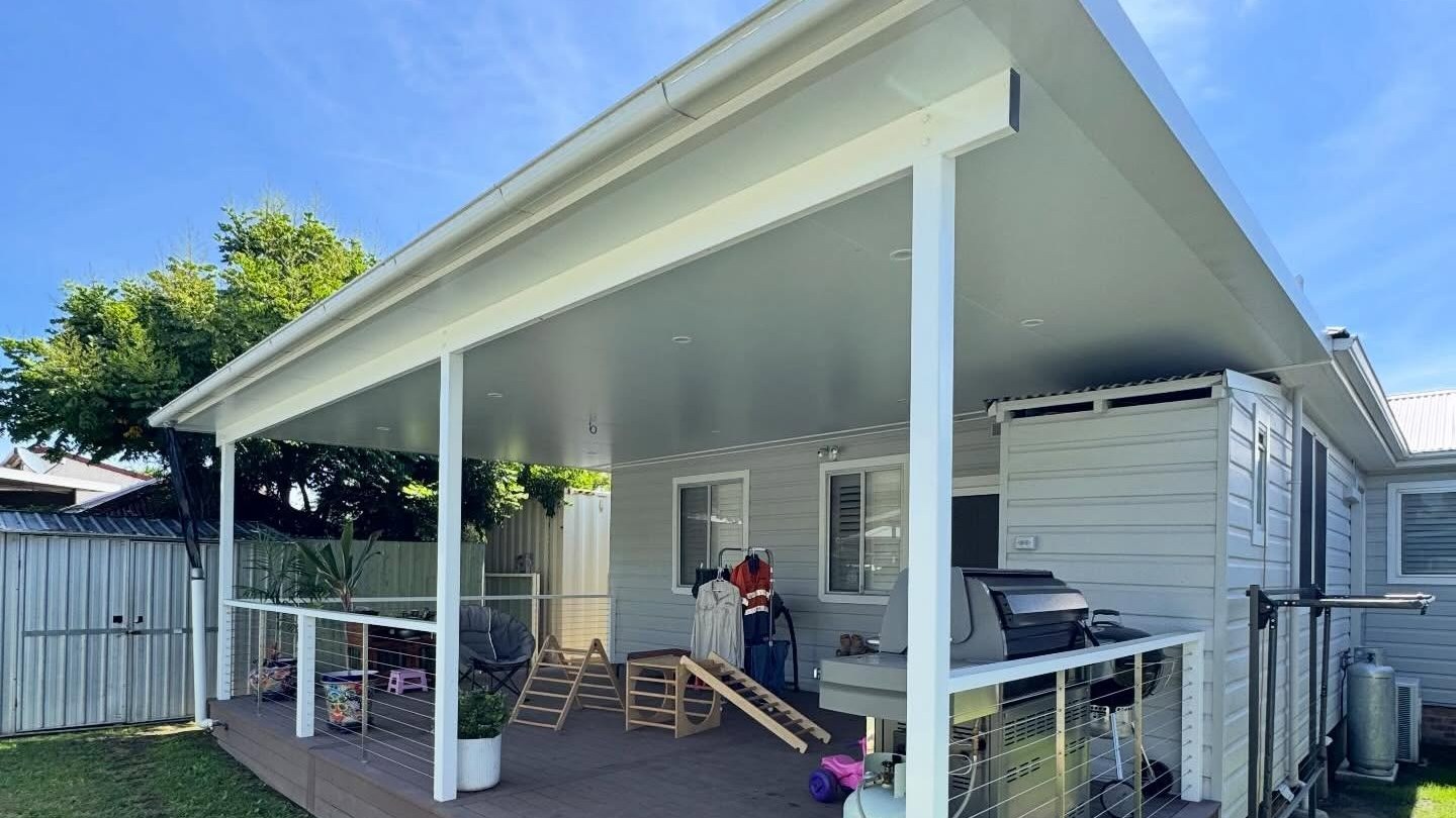 Finished Kurri Kurri deck with insulated patio cover, white posts and cable-style outdoor living